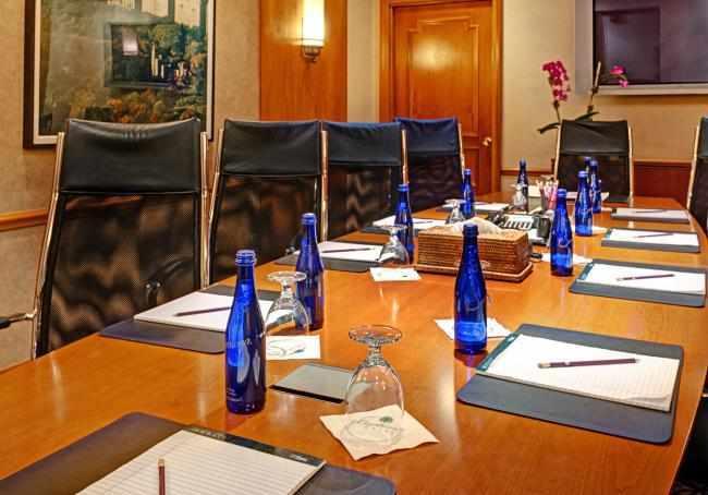 Boardroom table with bottles of water and notepads