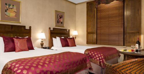 Premium rooms with 2 Queen beds have a bistro table and two chairs.